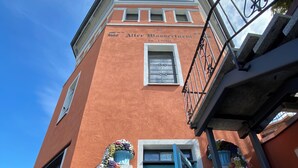 A building with a red facade, a blue door, and a stone base. - Residenz im "alten Wasserturm" (Wuppertal)