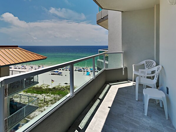 En balkon med udsigt over stranden og havet.