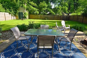 An outdoor patio with a glass-top table and four chairs, surrounded by a blue patterned rug. - 3 blocks from Nd, 3 bedroom 2 bath home(1815) (South Bend)