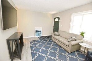 A living room with a sofa, a small table, a TV, and a patterned rug. - 3 blocks from Nd, 3 bedroom 2 bath home(1815) (South Bend)