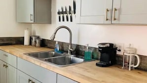 A kitchen with two sinks, a coffee maker, and a knife rack. - Home Getaway w/ Unique 🔥Fire Pit. Near Napa & SF (Vallejo)