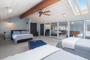A bedroom with a large bed, a smaller bed, a ceiling fan, and a skylight. - *NEW* Lakeside Club - 10 Minutes to Harbor Springs and Petoskey! (Petoskey)