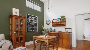 Un espace repas comprenant une table en bois, des chaises, un buffet et un tableau noir servant de panneau publicitaire pour les restaurants locaux.