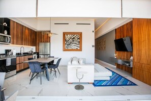 Un espacio moderno de estar con comedor, cocina y zona de asientos.