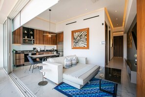 Una sala moderna con un sofá, una mesa de comedor y una cocina al fondo.