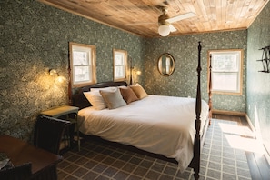 Classic design bedroom with a large bed, wooden nightstand, and floral wallpaper.