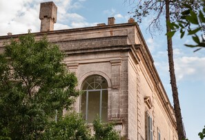 Un edificio de piedra con un amplio ventanal arqueado y una chimenea.