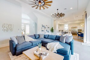 A modern living room with a sectional sofa, a coffee table, and decorative elements. - Modern Chic 9 Bedroom Mansion Sleeps 20 with Themed Rooms at Reunion Resort (Kissimmee)