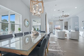 A modern dining area with a glass table, chairs, and a decorative fish sculpture.