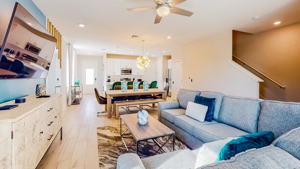 A modern living room with a sofa, coffee table, and a TV on a stand.