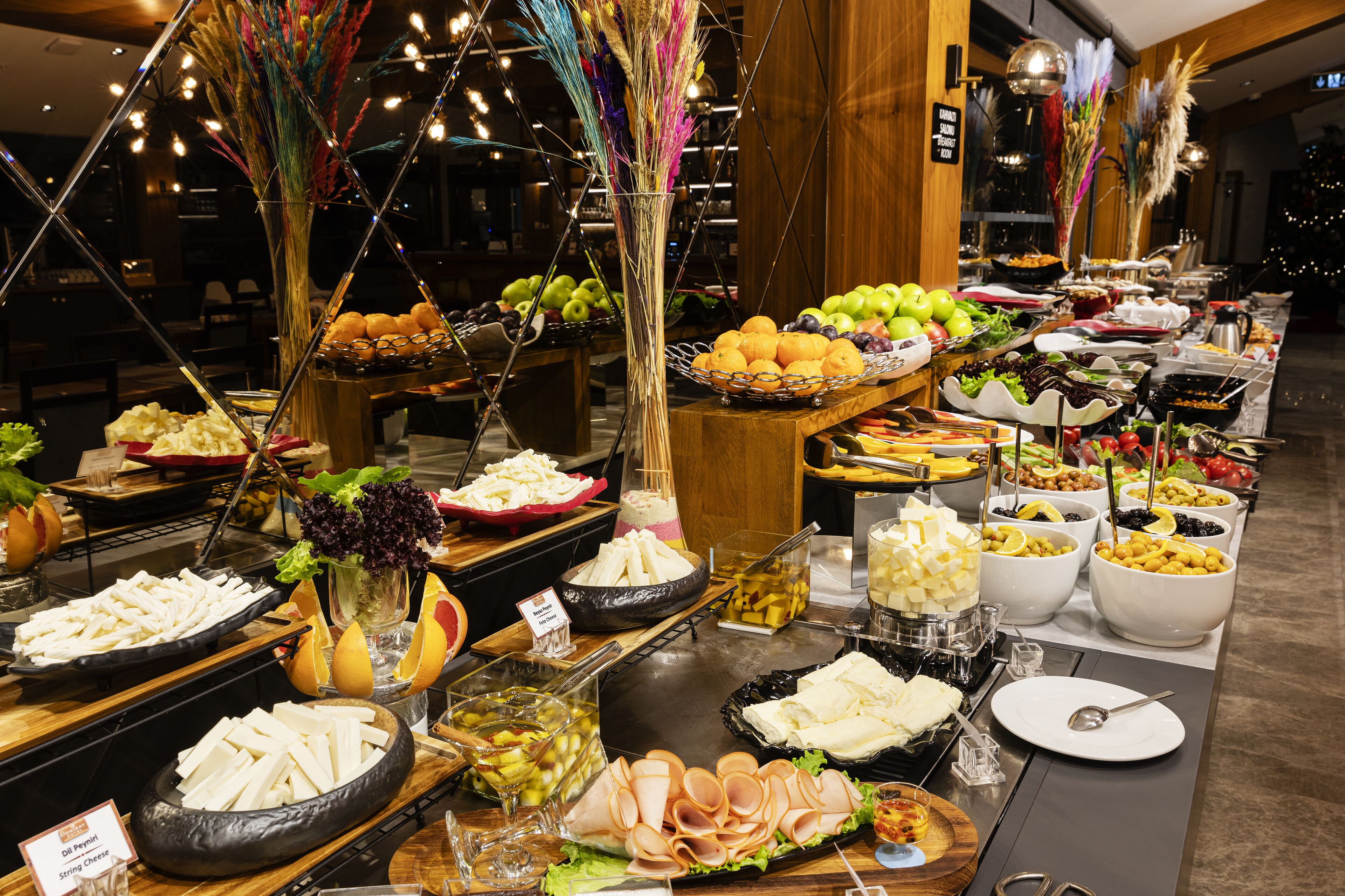 A buffet with various food items and a Christmas tree in the background.