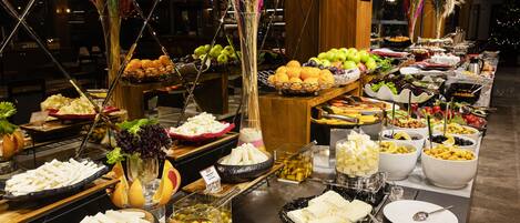 A buffet with various food items and a Christmas tree in the background.