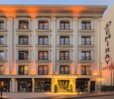 Un hotel de varios pisos con un diseño arquitectónico clásico, que presenta una entrada destacada con un cartel que dice "Demiray Hotel".