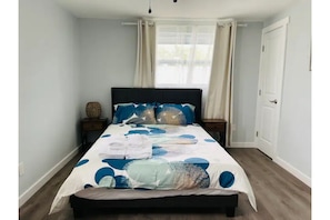 Cozy retreat with a large bed, two nightstands, and sheer curtains.