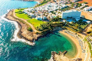 Vue aérienne d’une station balnéaire avec une plage, un grand hôtel et un terrain de golf.