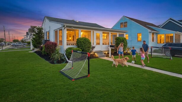 Una casa residencial con césped cuidado y un arco de fútbol.
