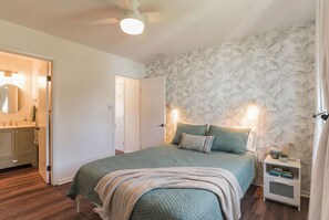A bedroom with a bed, nightstand, and a door leading to a bathroom. - Family-Friendly Beach Home - Steps to Beach & Bay - Porch, Yard, Garage (Brigantine)