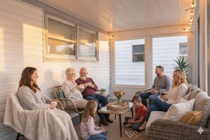 A cozy family gathering in a well-lit, open-plan living area with comfortable seating and a central table.