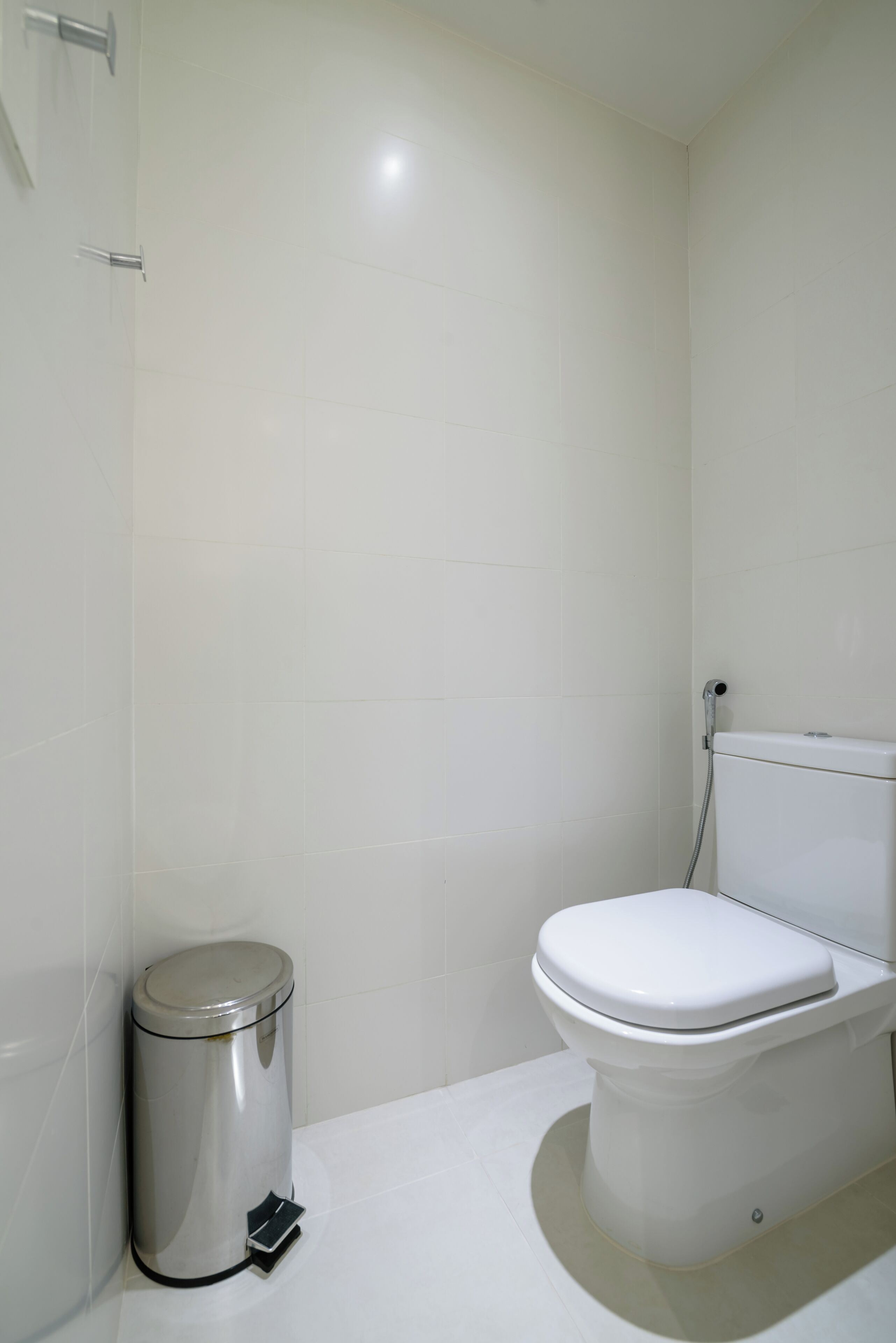 Un baño con inodoro y cubo de basura.