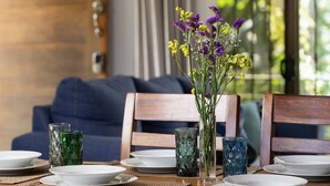 A dining table set with plates, glasses, and a vase of flowers. - Casa del Bosque, La Fortuna, Costa Rica (La Fortuna, San Carlos)