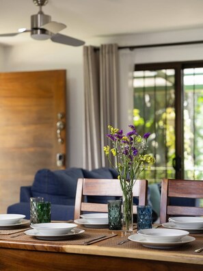 A dining table set with plates, glasses, and a vase of flowers. - Casa del Bosque, La Fortuna, Costa Rica (La Fortuna, San Carlos)