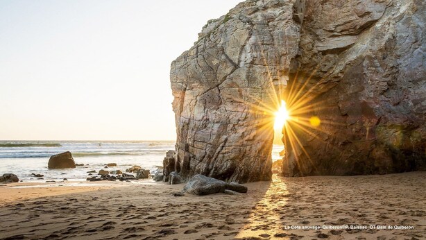A large rock formation on a beach with the sun setting behind it. - Cosy 3-star holiday home, 6 people (Ploeren)
