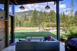 An outdoor seating area with a view of a mountainous landscape. - Base Camp 49 - Flagg Mountain Cabin 7B (Mazama)