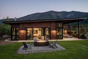 A modern house with a large deck, outdoor seating, and a fire pit. - Base Camp 49 - Goat Peak Cabin 11A (Mazama)