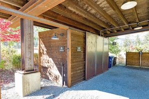 A covered outdoor area with a gravel floor, wooden walls, and metal doors labeled 'Ski Wax Hut.' - Base Camp 49 - Goat Peak Cabin 11A (Mazama)