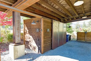 A covered outdoor area with a gravel floor, wooden walls, and metal doors labeled 'Ski Wax Hut.' - Base Camp 49 - Lucky Jim Cabin 11B (Mazama)
