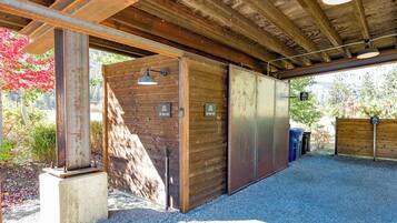 Un espacio exterior cubierto con suelo de grava, paredes de madera y puertas metálicas con la inscripción 'Ski Wax Hut'.
