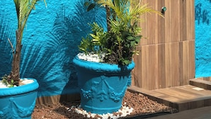 A blue wall with a wooden door and potted plants. - Pousada Turquesa by Gente Bonita (Búzios)