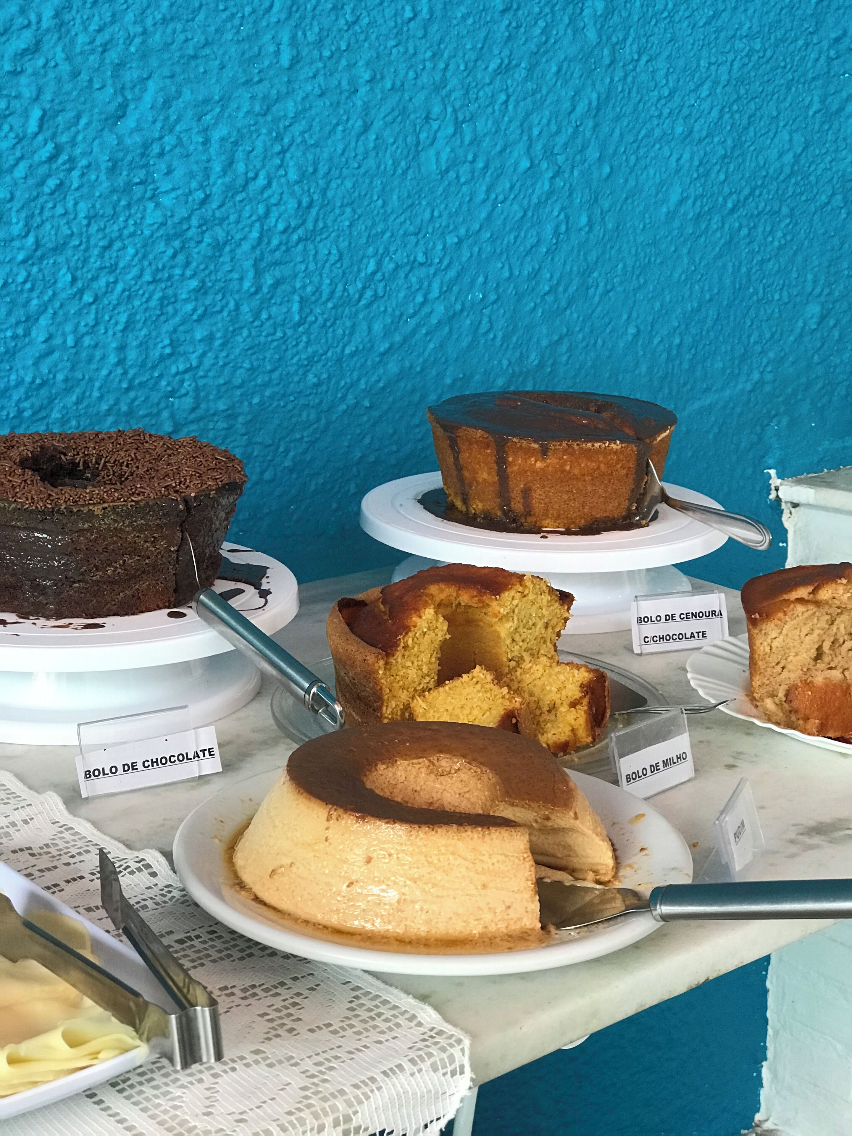 A display of various cakes on a table with labels.