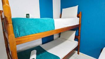 A bunk bed with a blue wall and white floor tiles.