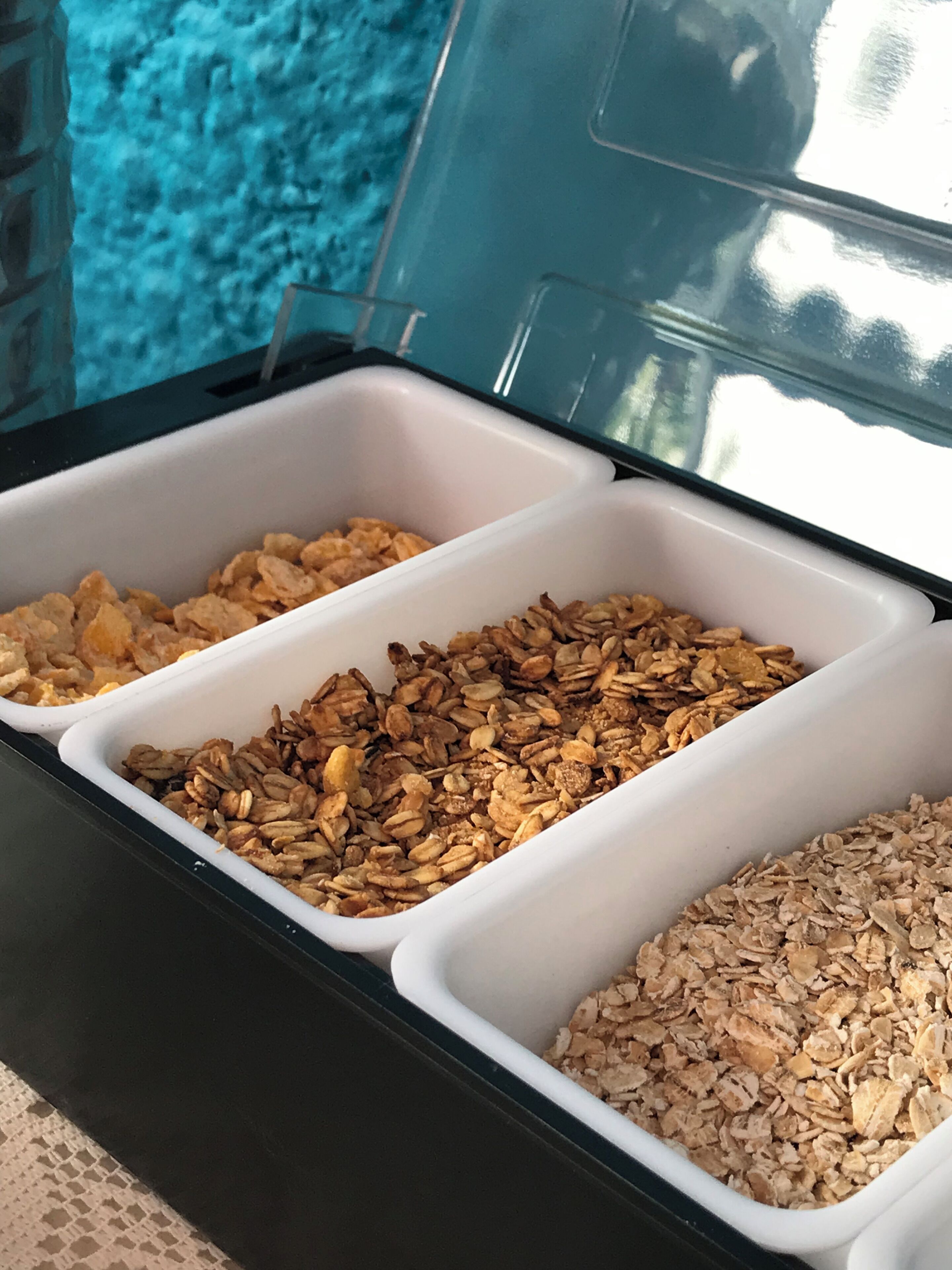 Un comptoir de petit-déjeuner avec trois récipients remplis de granola.