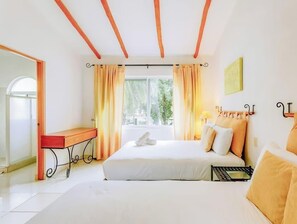A hotel room with a bed, bedside table, and a window with curtains.