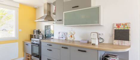 A compact kitchen with a stove, oven, and modern appliances.