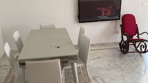 A conference room with a marble floor, a white table, and six chairs. - THE GOOD ADRESS (Ariana)