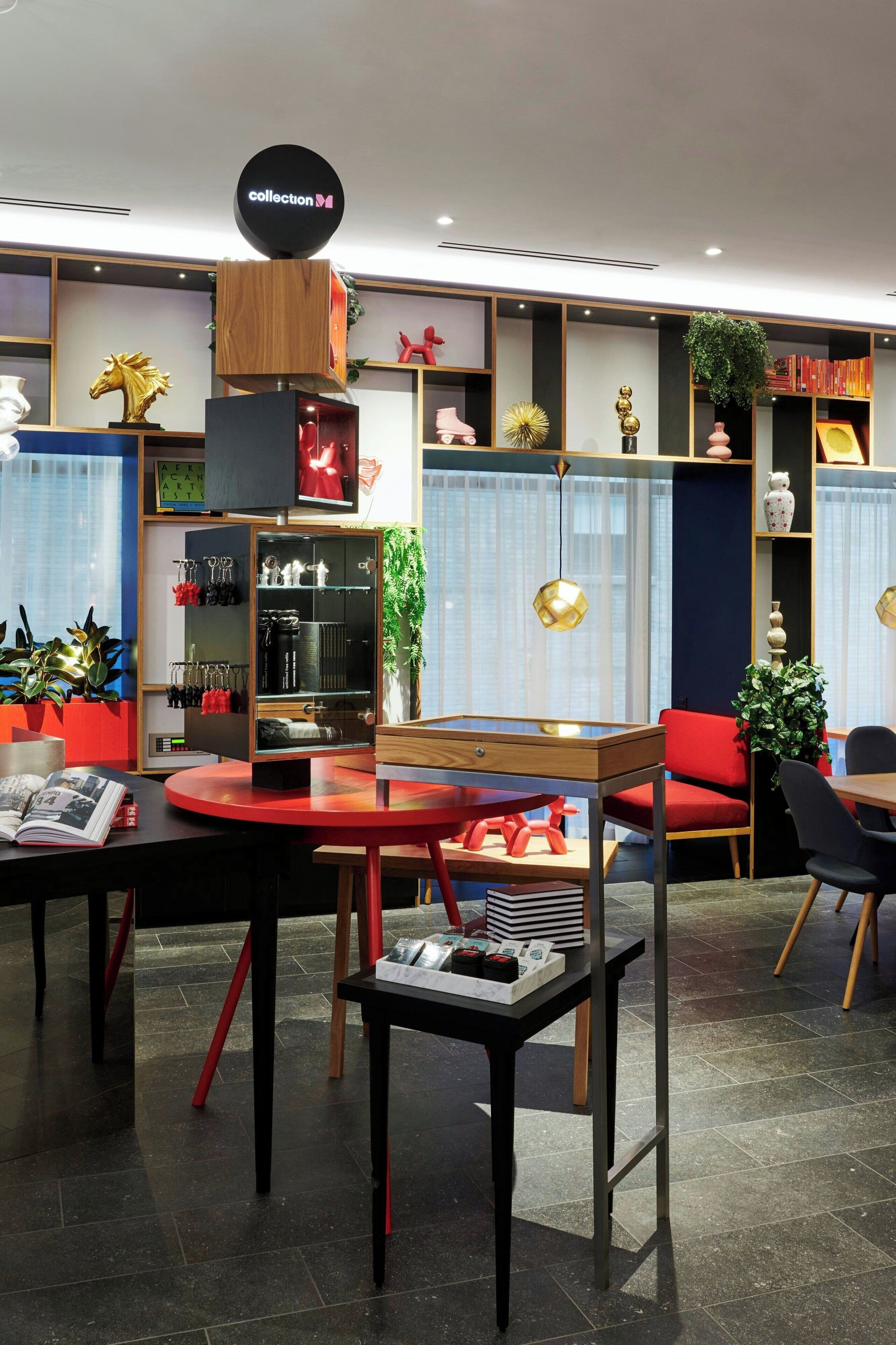 A modern interior with a central round table, a bookshelf, and a sign reading "collection".