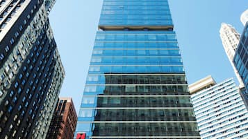 A tall, modern skyscraper with a glass facade, surrounded by other high-rise buildings.