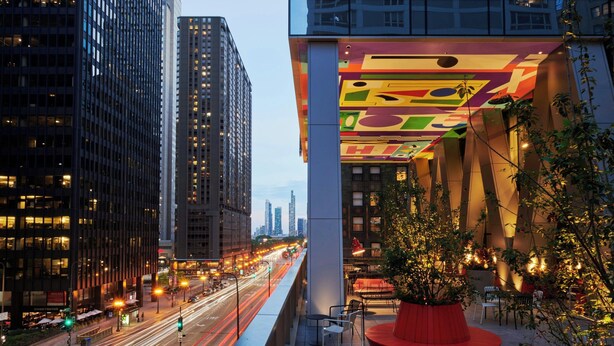 A modern building with a colorful facade and a red circular seating area.