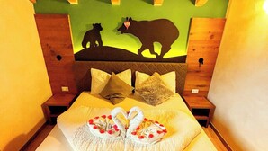 A room with a bed, wooden headboard, and a wall mural of animals.