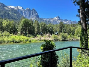 Une rivière bordée de montagnes, entourée d’une végétation luxuriante et d’arbres.