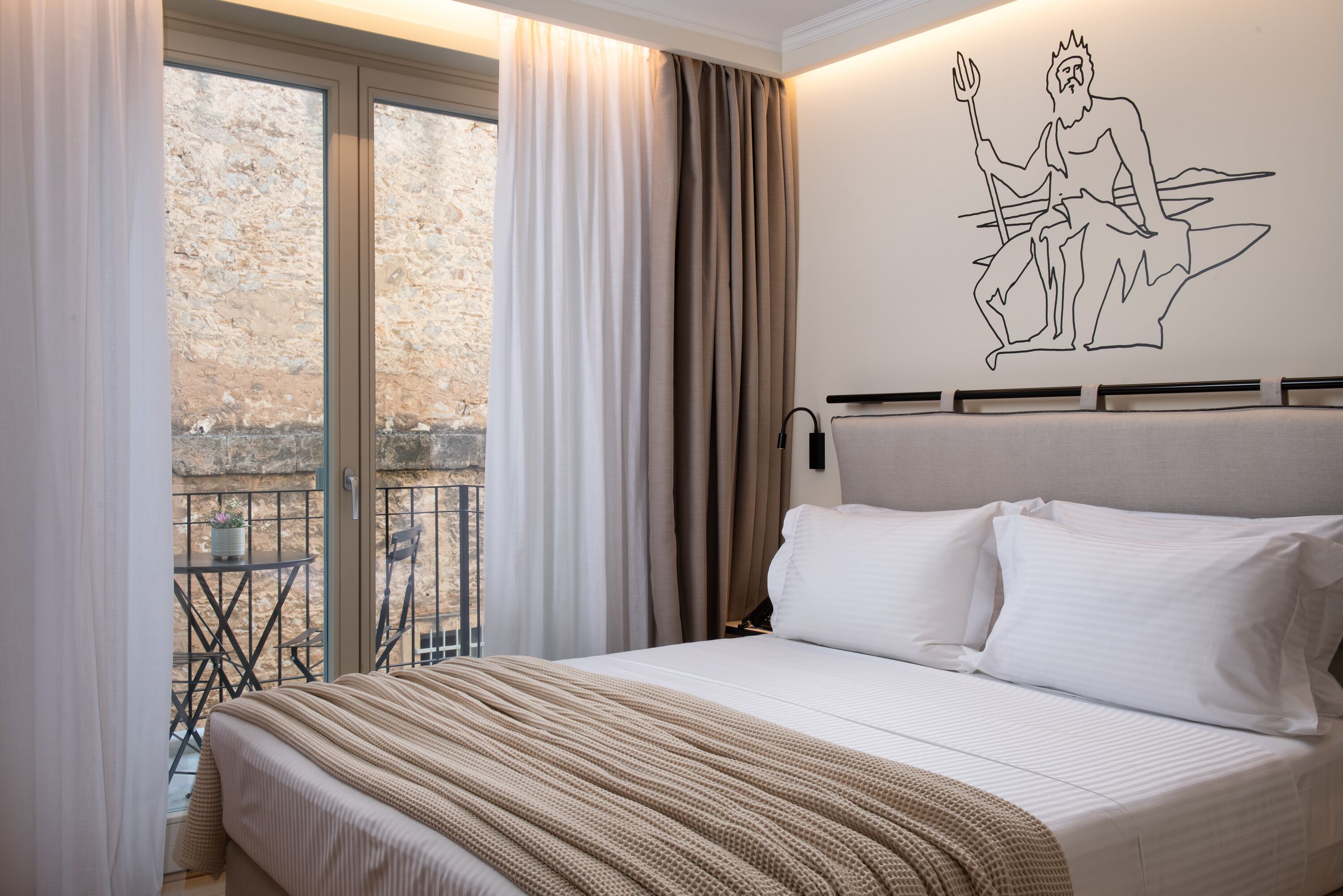A bedroom with a large bed, a view of a balcony, and a wall mural.