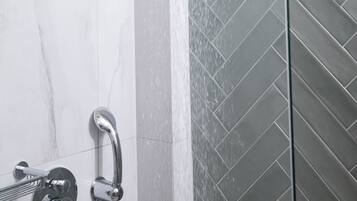 Ducha de diseño moderno, con cabezal de ducha curvo y panel de control.