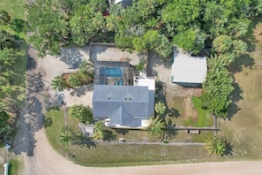 Surrounded by lush vegetation, this single-story house offers a serene retreat with a pool area.