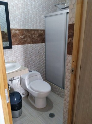 A bathroom with a toilet, sink, and shower. - Hotel Royal Olympic (Chiclayo)