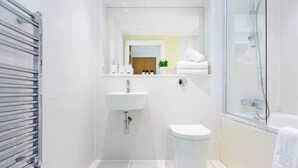 Un bagno moderno con lavandino, wc e vasca da bagno bianchi.