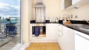 Una cucina moderna con un'ampia finestra, un forno integrato e una cappa aspirante in acciaio inossidabile.