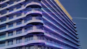 Un hôtel à plusieurs étages, doté d’une façade incurvée et de balcons.